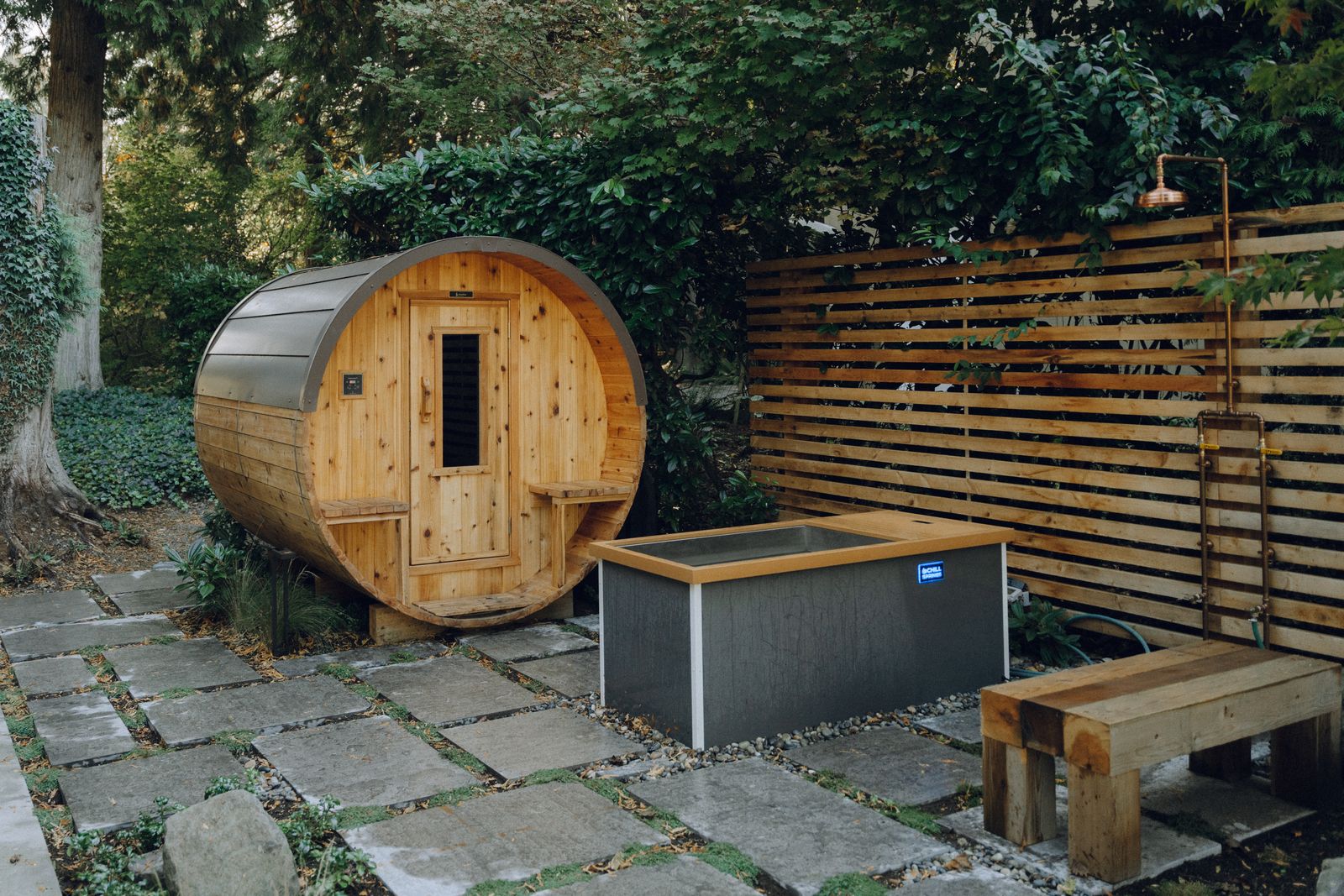 Barrel sauna and cold plunge on a flagstone patio